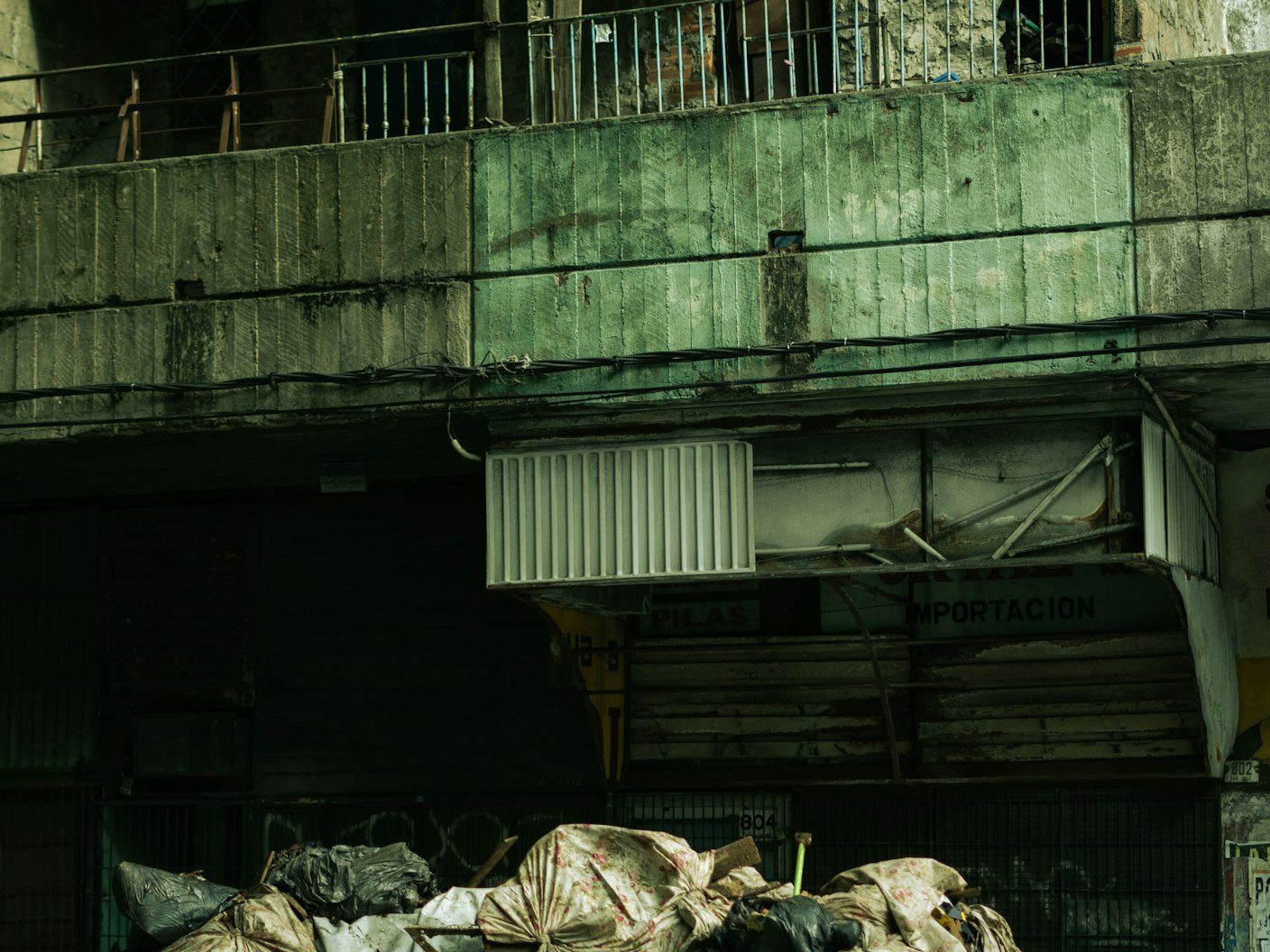 Yellow open-top skip overflowing with bags on a pavement