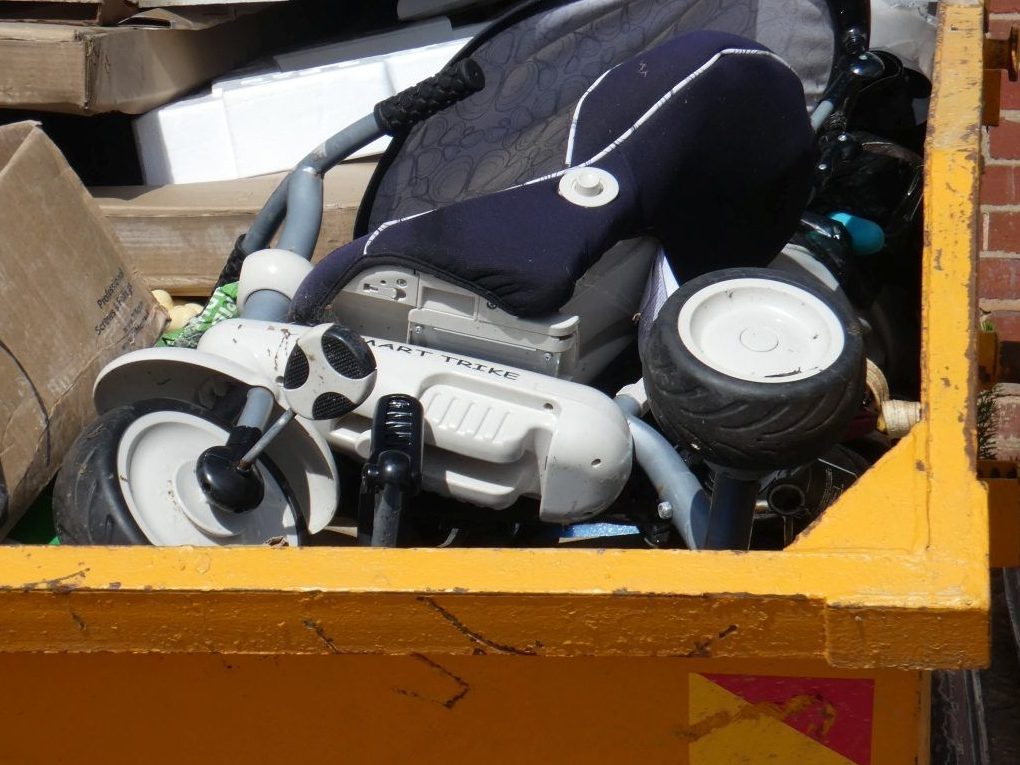 Close-up of a yellow UK skip filled with DIY waste